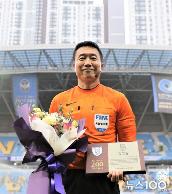 K리그 200경기 출전 기념패를 받고 포즈를 취한 김대용 심판.