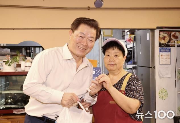 박승원 광명시장이 지난 9월 '추석명절 물가안정 대비 전통시장 물가체험'으로 광명전통시장을 방문해 상품 구입 후 상인과 광명사랑화폐 카드를 들고 기념사진을 촬영하는 모습