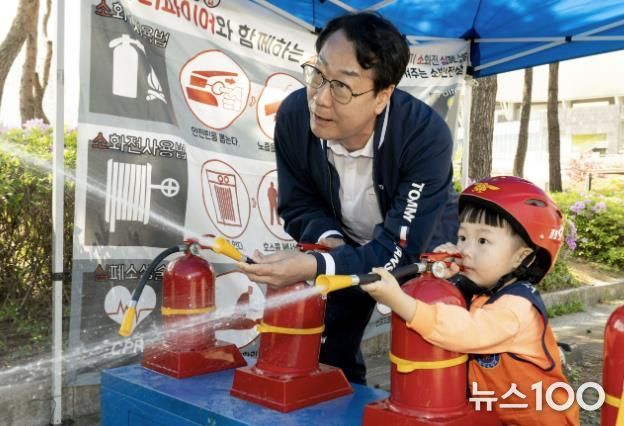 정명근 화성특례시장이 화성특례시 어린이날 영유아가족 어울림축제에서 어린이와 함께 소화기 사용 체험을 하고 있다.