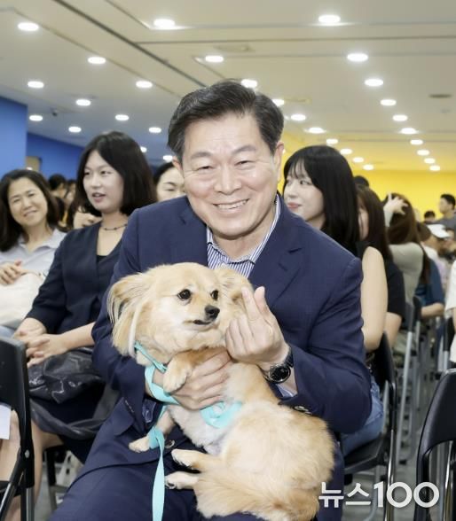 박승원 광명시장이 지난 13일 광명시민회관 전시실에서 열린 반려동물 전시회에 참석해 입양 당일 새 가족을 만난 유기견 '룽지'를 품에 안고 입양의 의미를 알리는 기념사진을 촬영하고 있다.