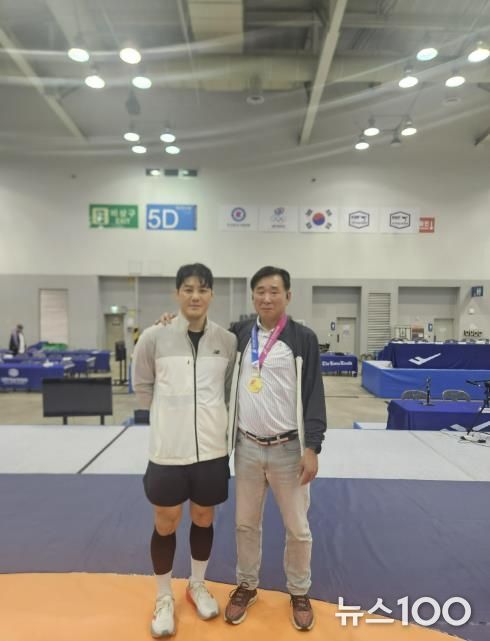 레슬링부 윤창희 감독과 김현우 선수가 기념사진을 찍고 있다.