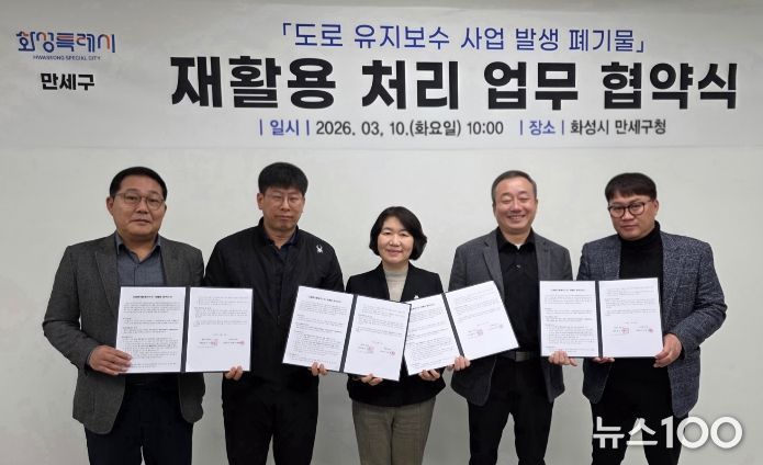 화성특례시 만세구와 관내 아스콘 생산 업체 관계자들이 폐아스콘 재활용 처리 협약을 체결한 뒤 협약서를 들고 기념촬영을 하고 있다