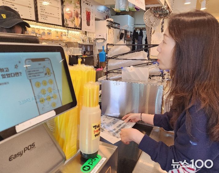 화산동 관계자가 카페를 방문해 종이팩 별도 수거 사업을 홍보하며 전용 수거 봉투를 전달하고 있다